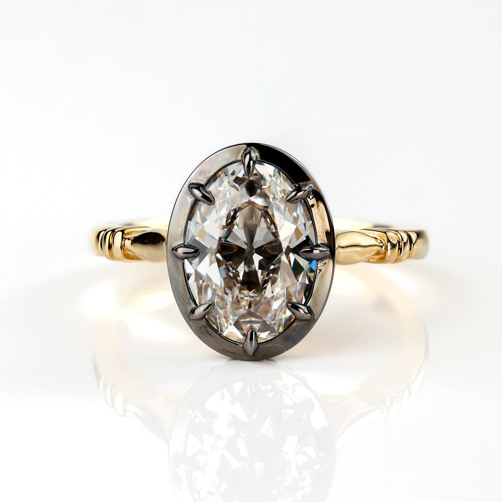 The Caroline ring: antique oval lab-grown diamond in a blackened collet on a yellow gold snake shank